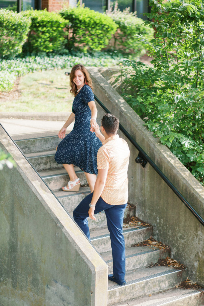 woman leading husband up stairs under a tree